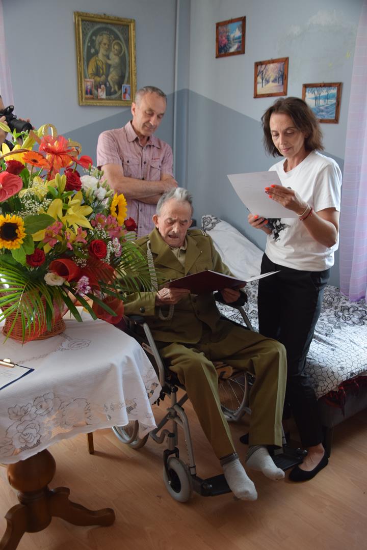Zdjęcie przedstawiające Pana Stanisława Piekarskiego wraz z rodziną przyjmującego gratulacje i życzenia urodzinowe
