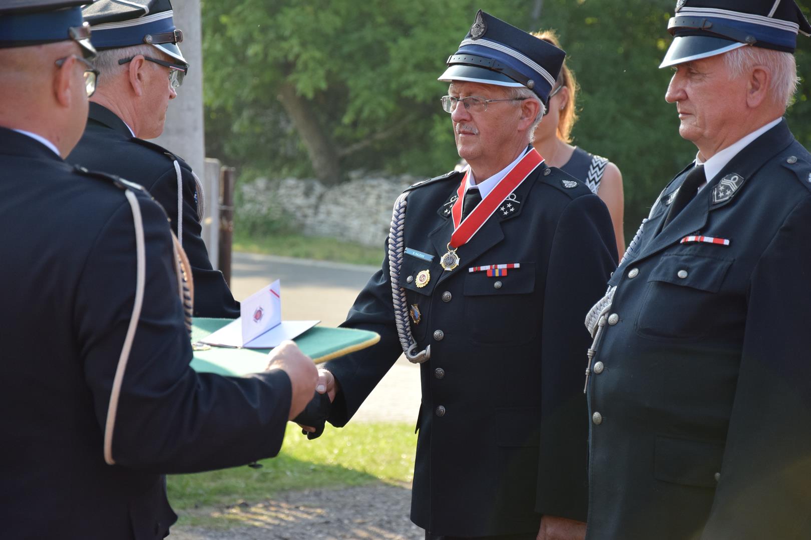 Zdjęcie przedstawia fragment uroczystości 100 lecia OSP Toporowice - wręczanie medali, odznaczeń i nagród