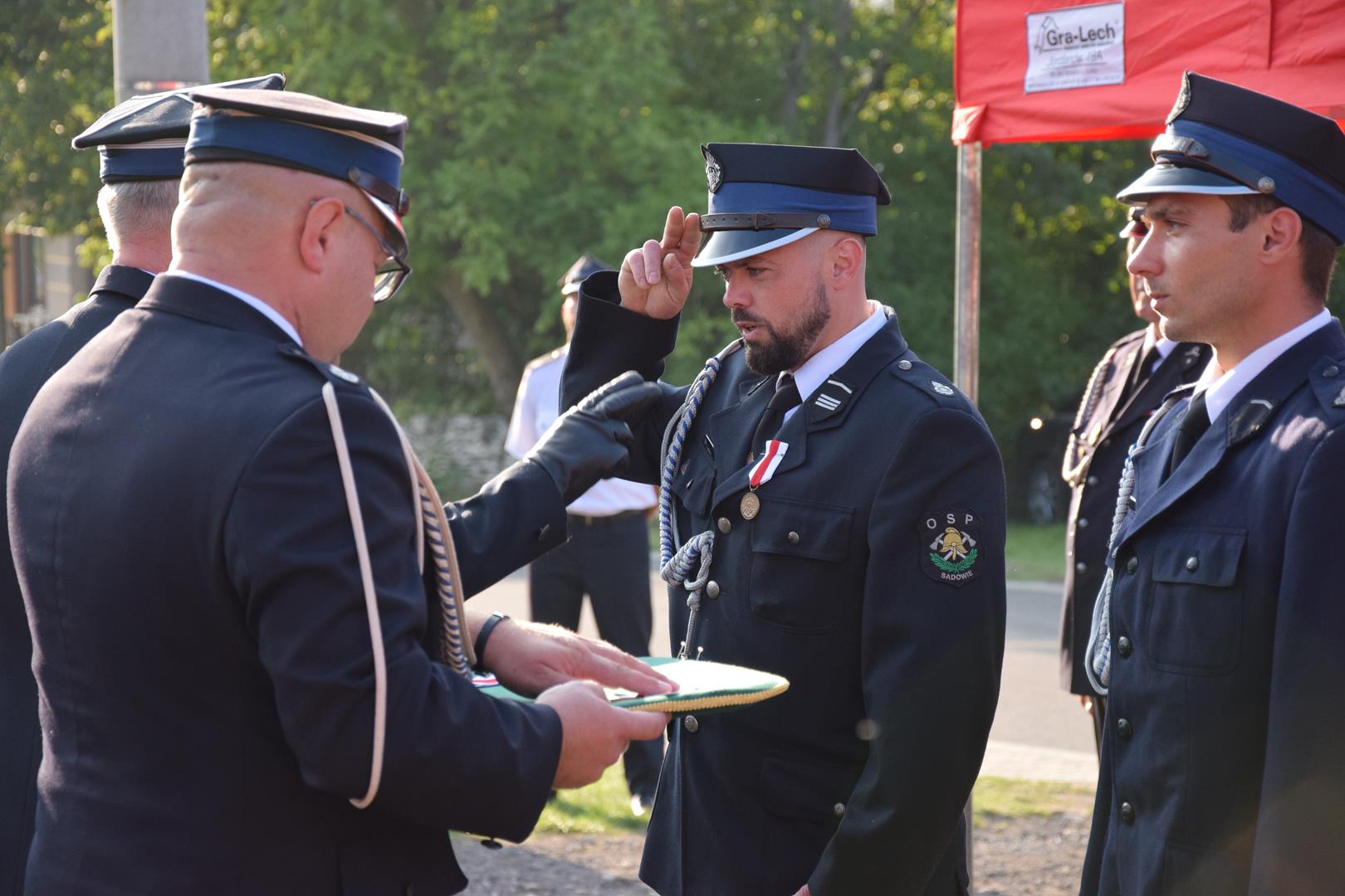 Zdjęcie przedstawia fragment uroczystości 100 lecia OSP Toporowice - wręczanie medali, odznaczeń i nagród