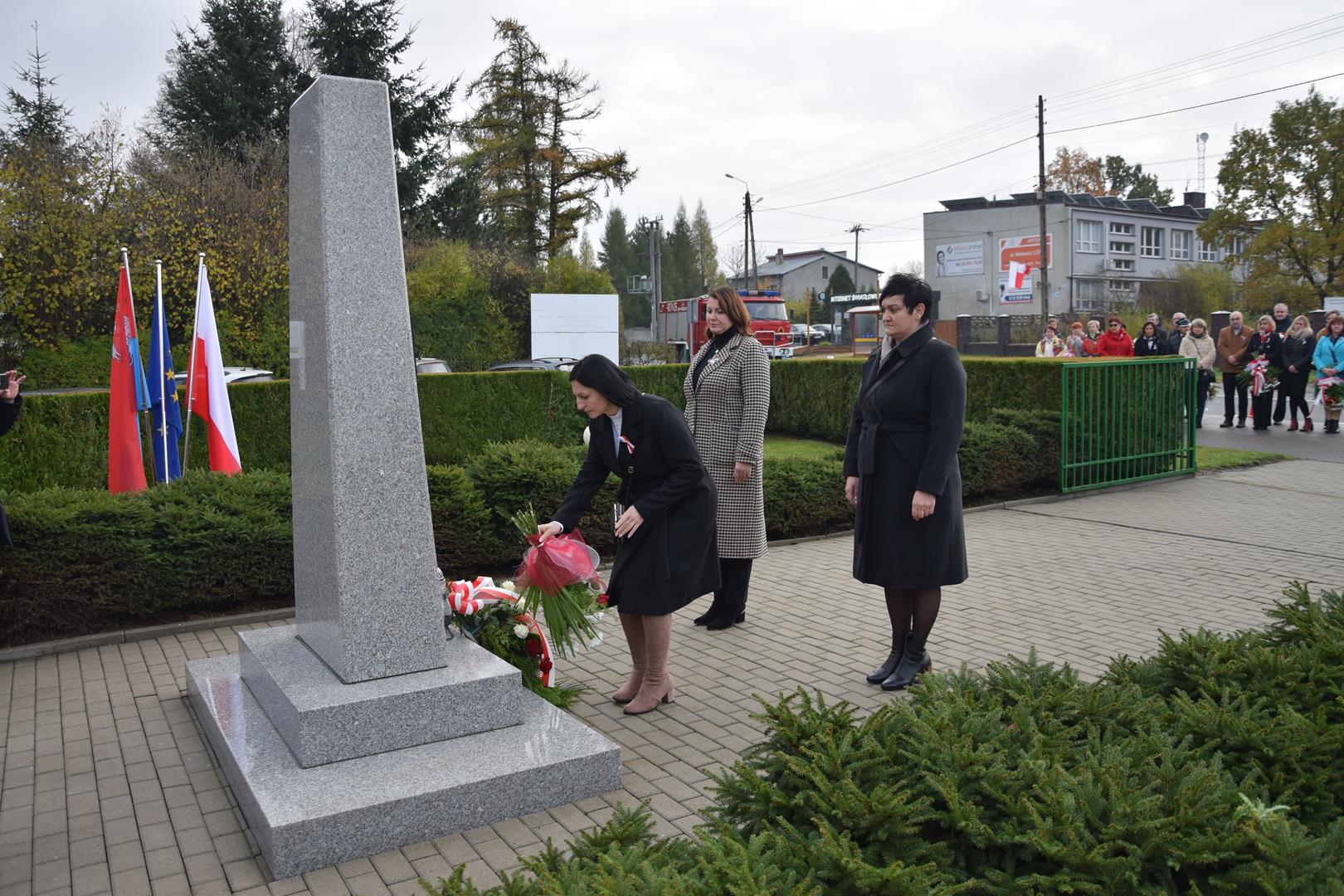 Zdjęcie przedstawia moment składania kwiatów przed pomnikiem przez reprezentantów rady gminy Mierzęcice