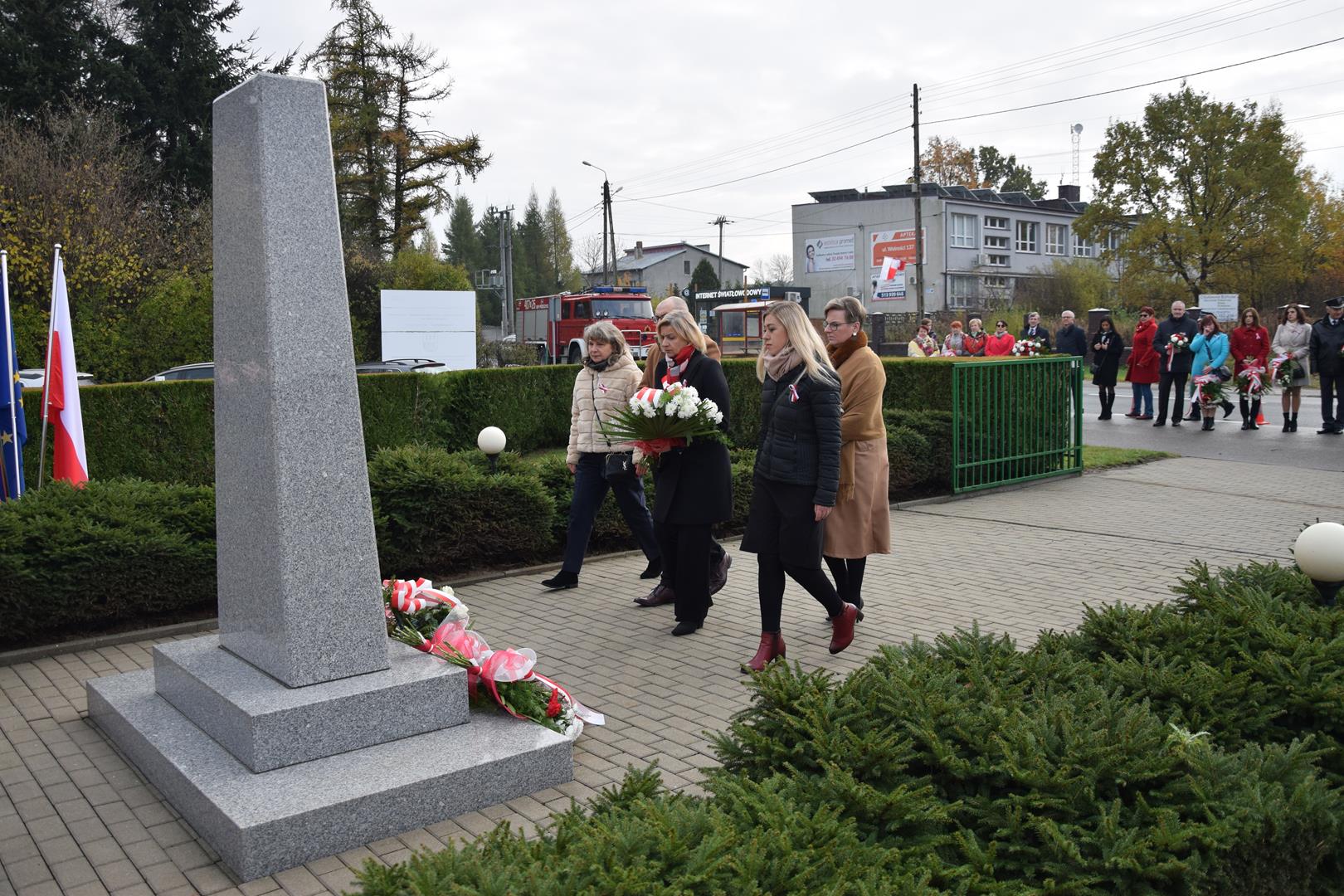 Zdjęcie przedstawia moment składania kwiatów przed pomnikiem przez reprezentantów jednostek oświatowych gminy Mierzęcice