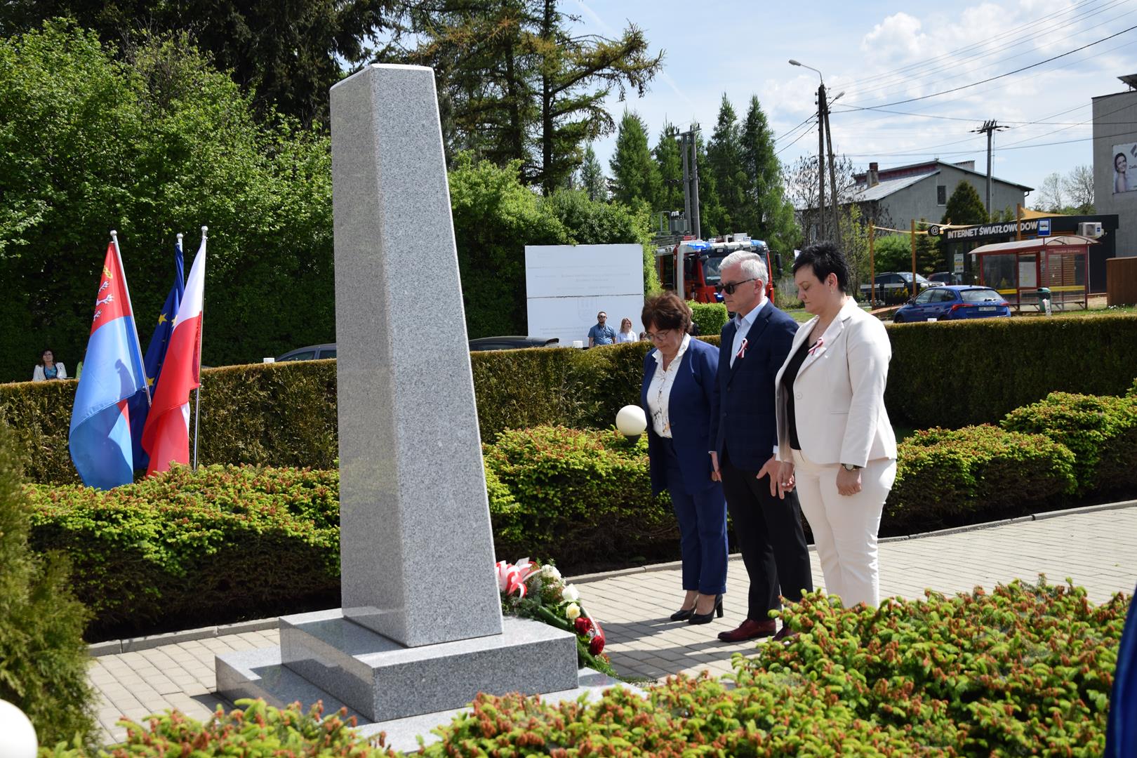 Zdjęcie przedstawia moment składania kwiatów pod pomnikiem przez delegację rady gminy Mierzęcice