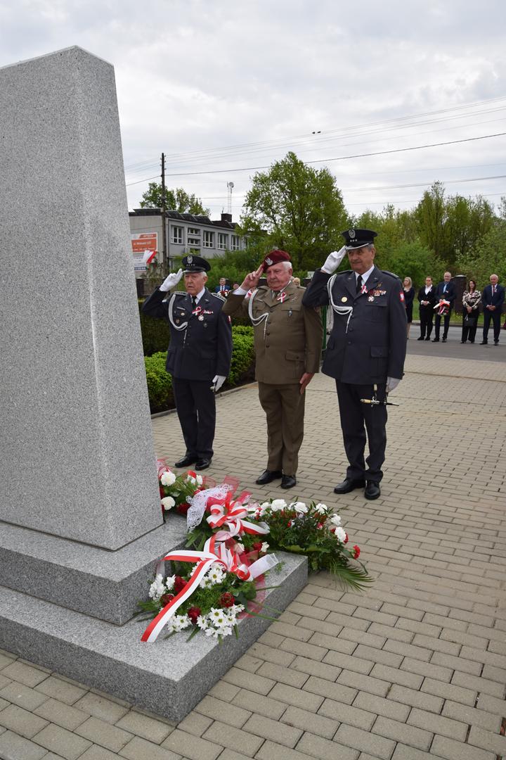 Zdjęcie przedstawia moment składania kwiatów pod pomnikiem przez delegację Stowarzyszenia Seniorów Lotnictwa Wojskowego RP Oddział Śląski im. 39 Pułku Lotnictwa Myśliwskiego OPK