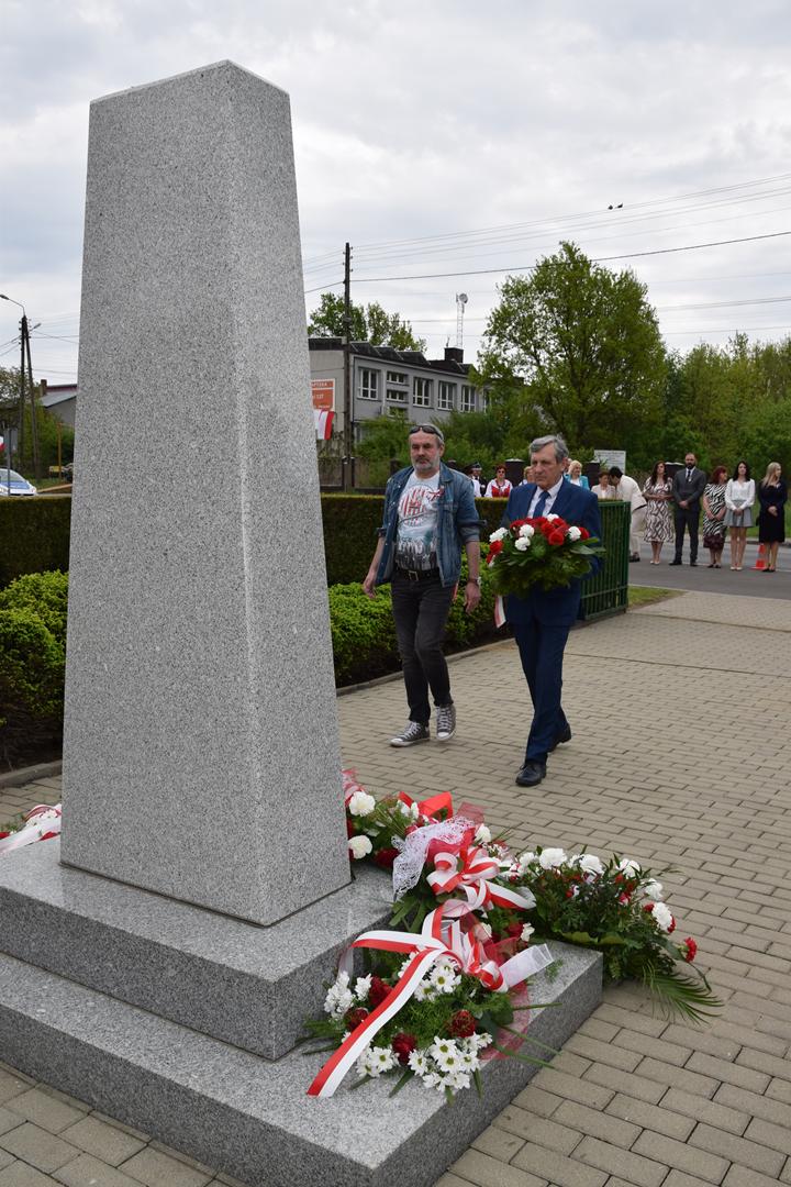 Zdjęcie przedstawia moment składania kwiatów pod pomnikiem przez delegację Mieszkańców Gminy Mierzęcice