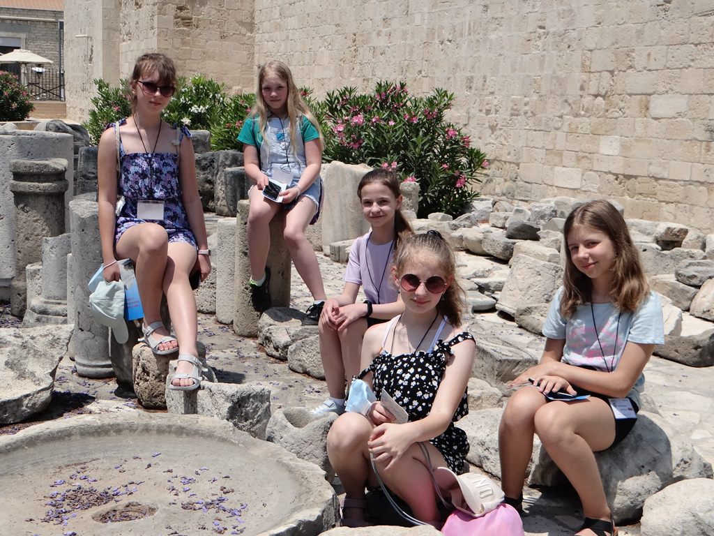 Zdjęcie przedstawiające dzieci siedzące na kamieniach