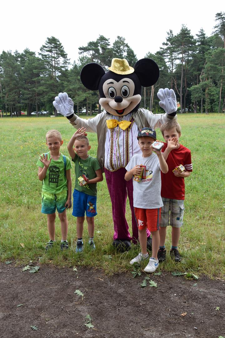 Zdjęcie przedstawiające dzieci pozujących z Myszką Miki 