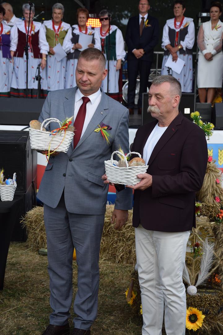 Zdjęcie przedstawia moment wręczania pamiątkowych chlebów dożynkowych