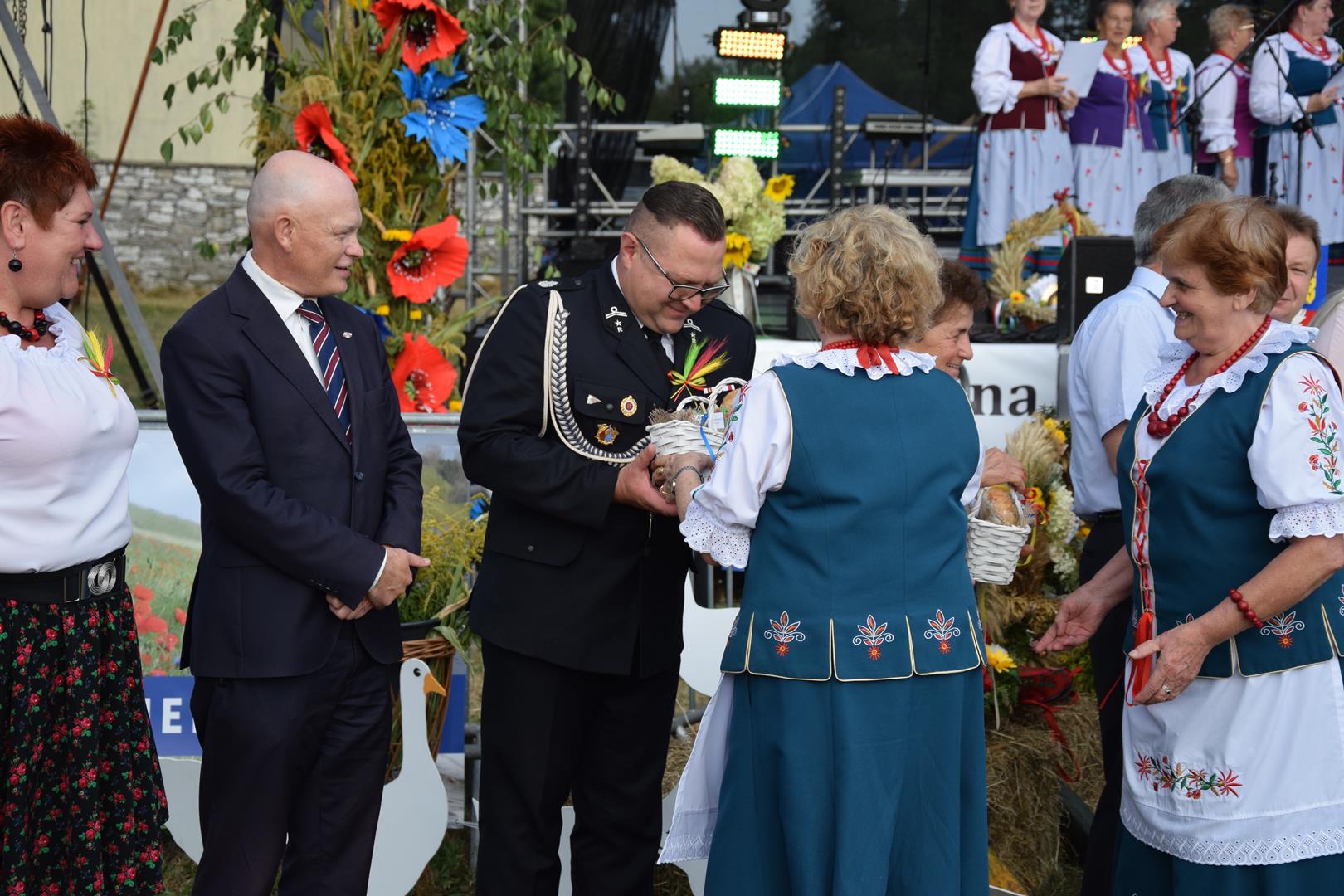 Zdjęcie przedstawia moment wręczania pamiątkowych chlebów dożynkowych