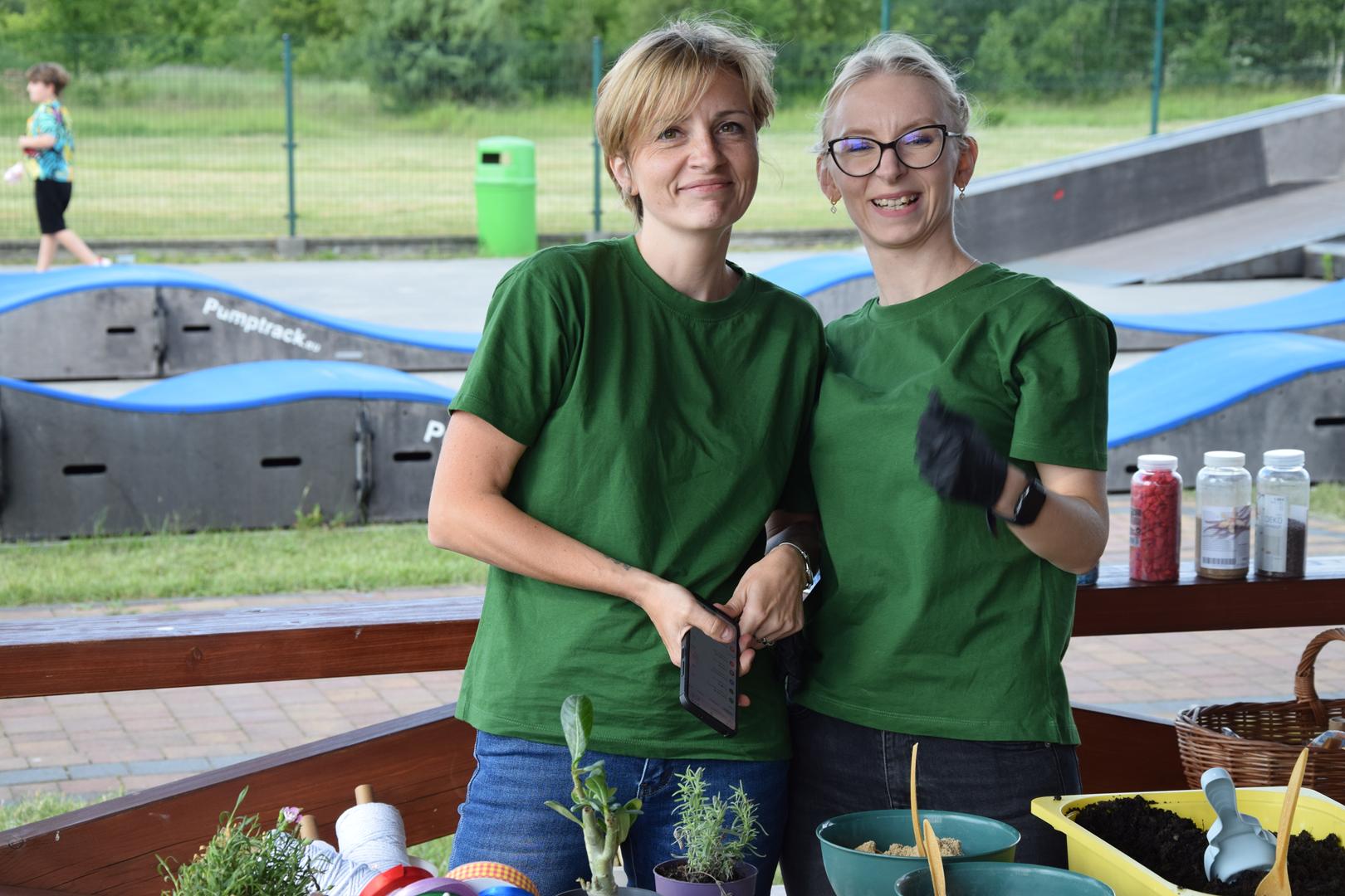 Zdjęcie przedstawia organizatorów pozujących do zdjęcia przy stanowisku lasów w szkle