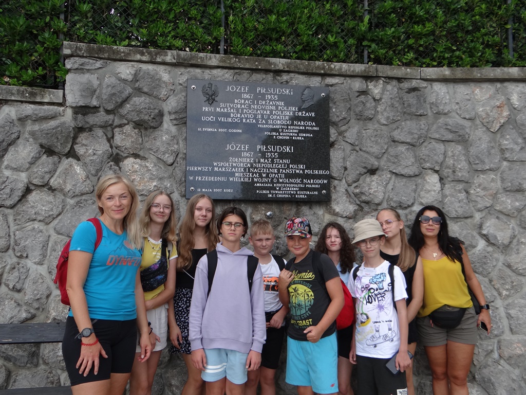 Zdjęcie przedstawiające uczniów z SP1 pod tablicą upamiętniajacą Józefa Piłsudskiego w Chorwacji
