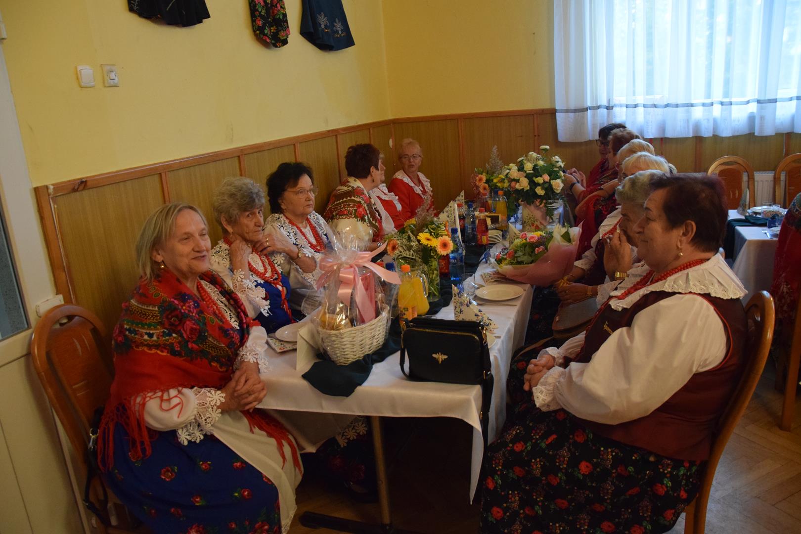 Zdjęcie przedstawia fragment uroczystości 65-lecia KGW Boguchwałowice - człońkinie KGW z terenu gminy Mierzęcice siedzące przy stoliku 