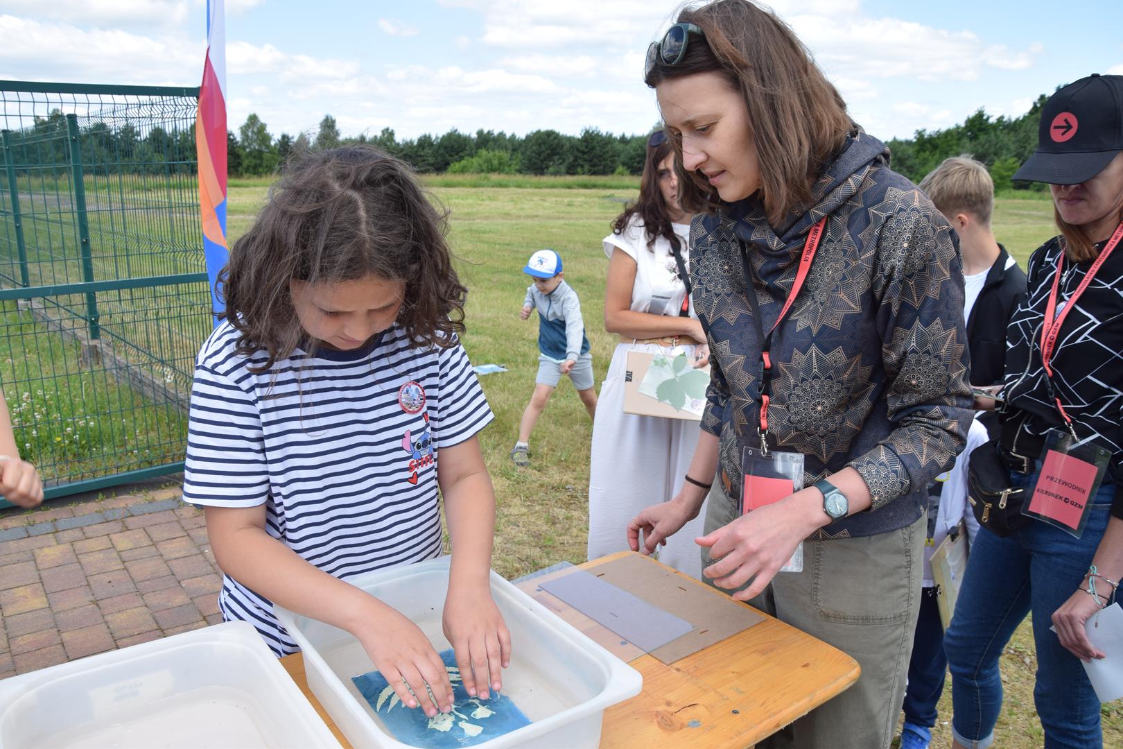 Zdjęcie przedstawia proces przygotowania pracy w technice cyjanotypi