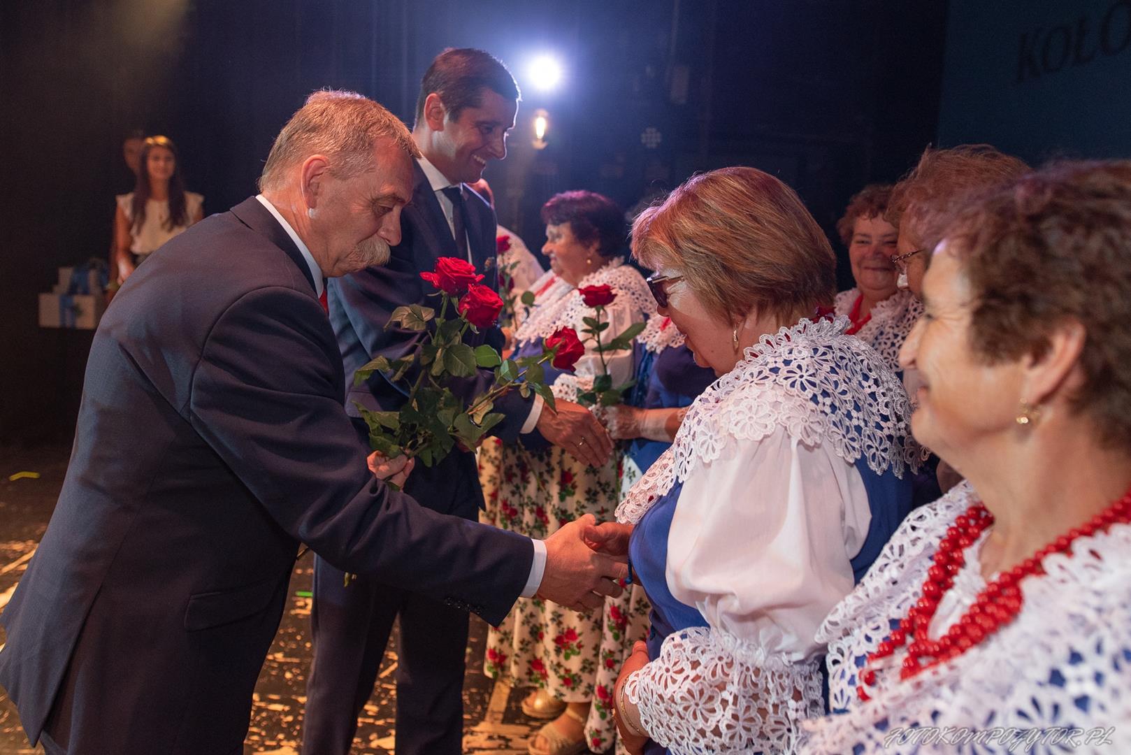 Zdjęcie przedstawia moment wręczenia kwiatów podczas uroczystości
