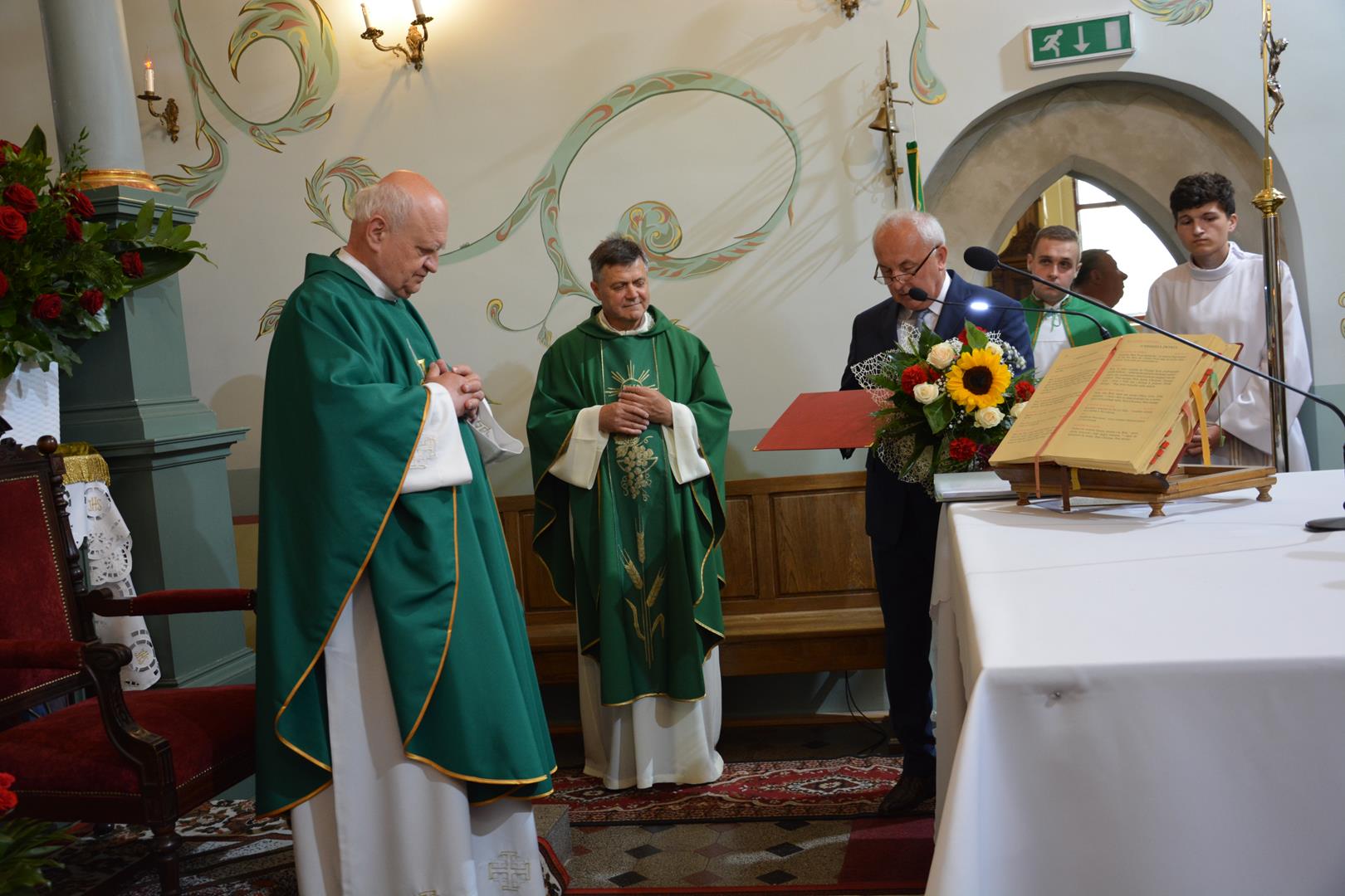 Zdjęcie przedstawiające księdza proboszcza Janusza Rakoczego przyjmującego podziękowania i gratulacje od Wójta Gminy Mierzęcice Grzegorza Podlejskiego