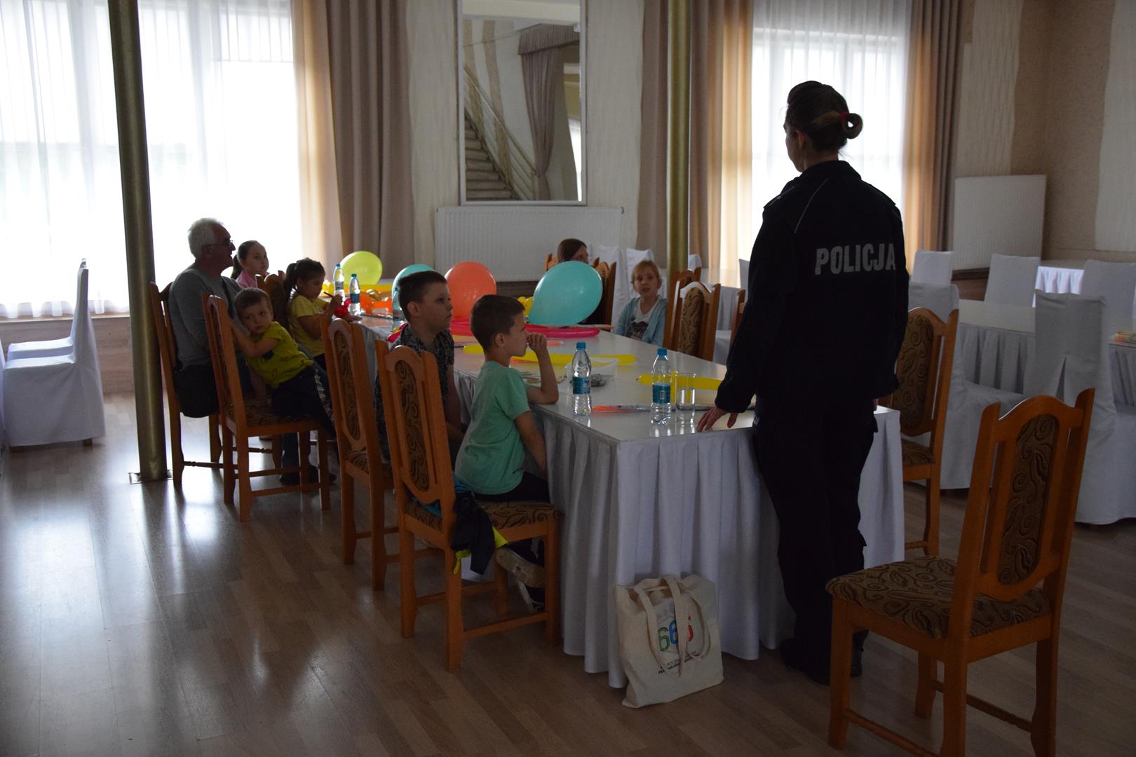 Zdjęcie przedstawia fragment spotkania edukacyjnego z policjantem