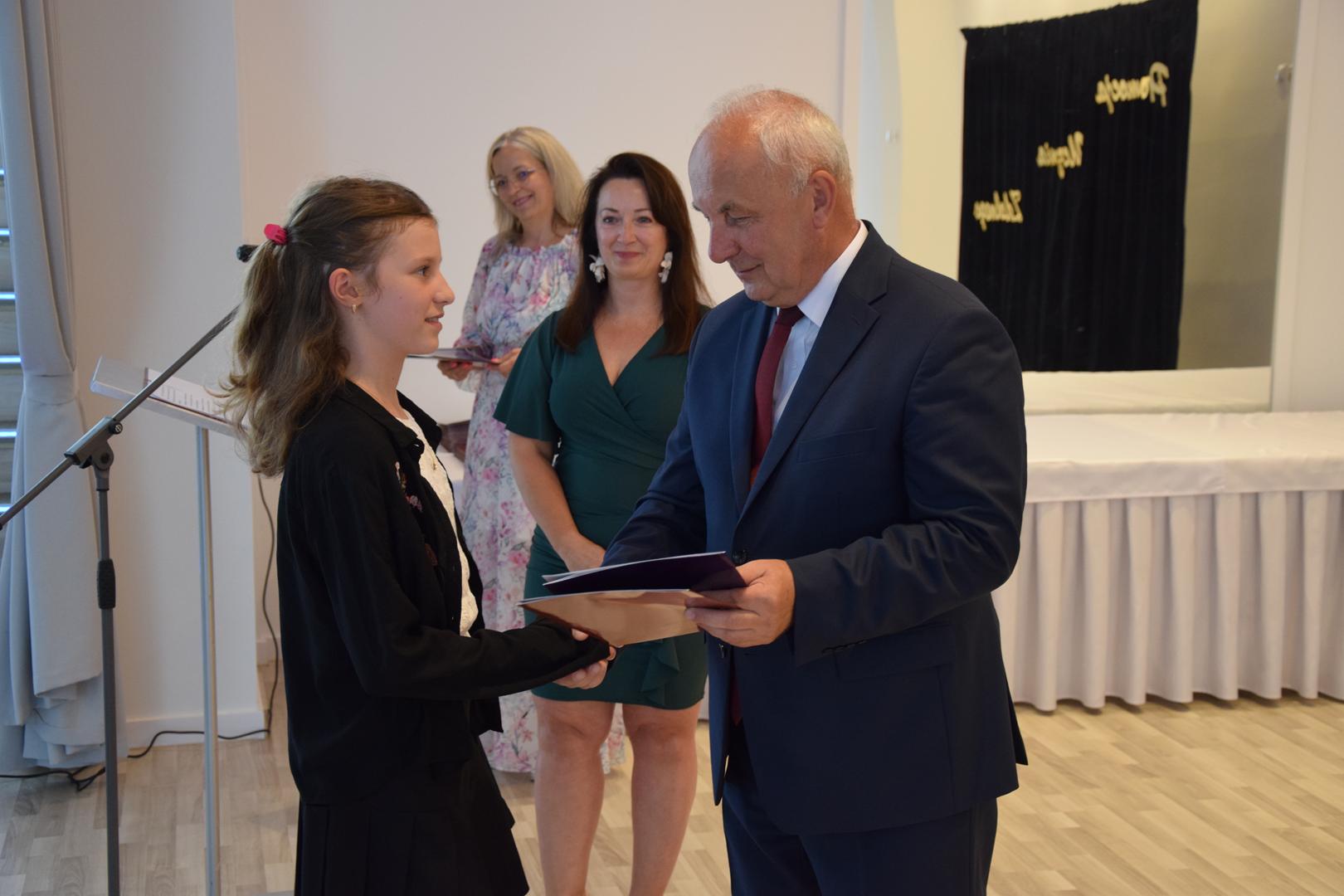 Zdjęcie przedstawia moment rozdania nagród i wyróżnień dla uczniów z najwyższą średnią ocen w Gminie Mierzęcice