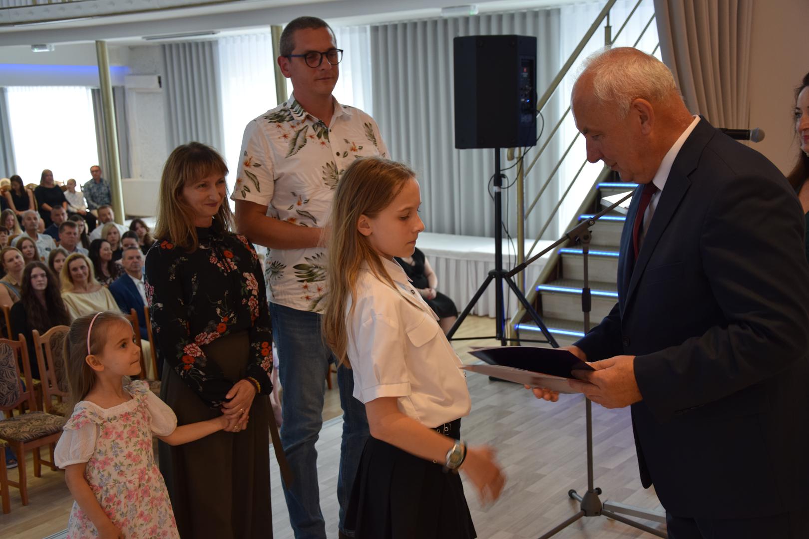 Zdjęcie przedstawia moment rozdania nagród i wyróżnień dla uczniów z najwyższą średnią ocen w Gminie Mierzęcice