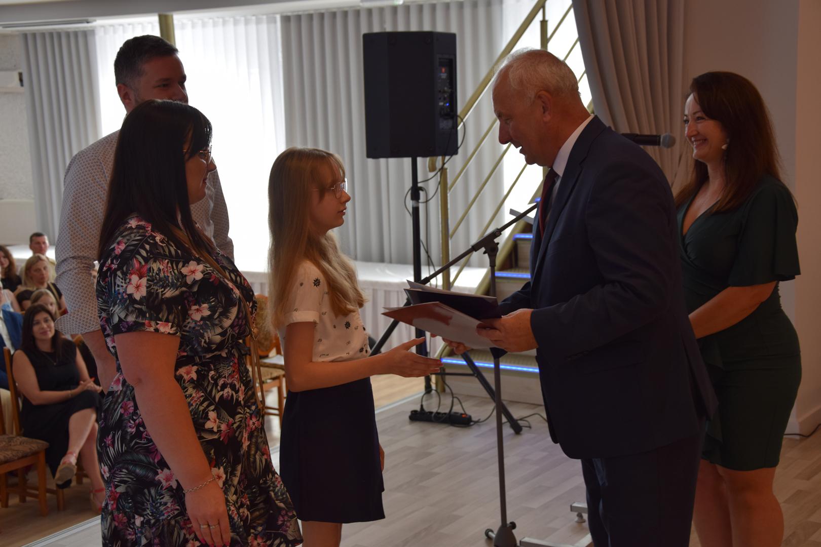 Zdjęcie przedstawia moment rozdania nagród i wyróżnień dla uczniów z najwyższą średnią ocen w Gminie Mierzęcice
