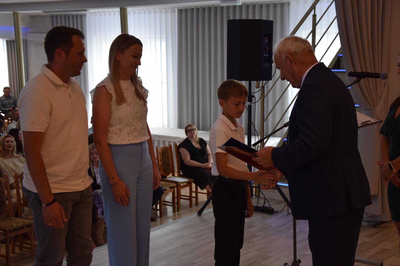 Zdjęcie przedstawia moment rozdania nagród i wyróżnień dla uczniów z najwyższą średnią ocen w Gminie Mierzęcice
