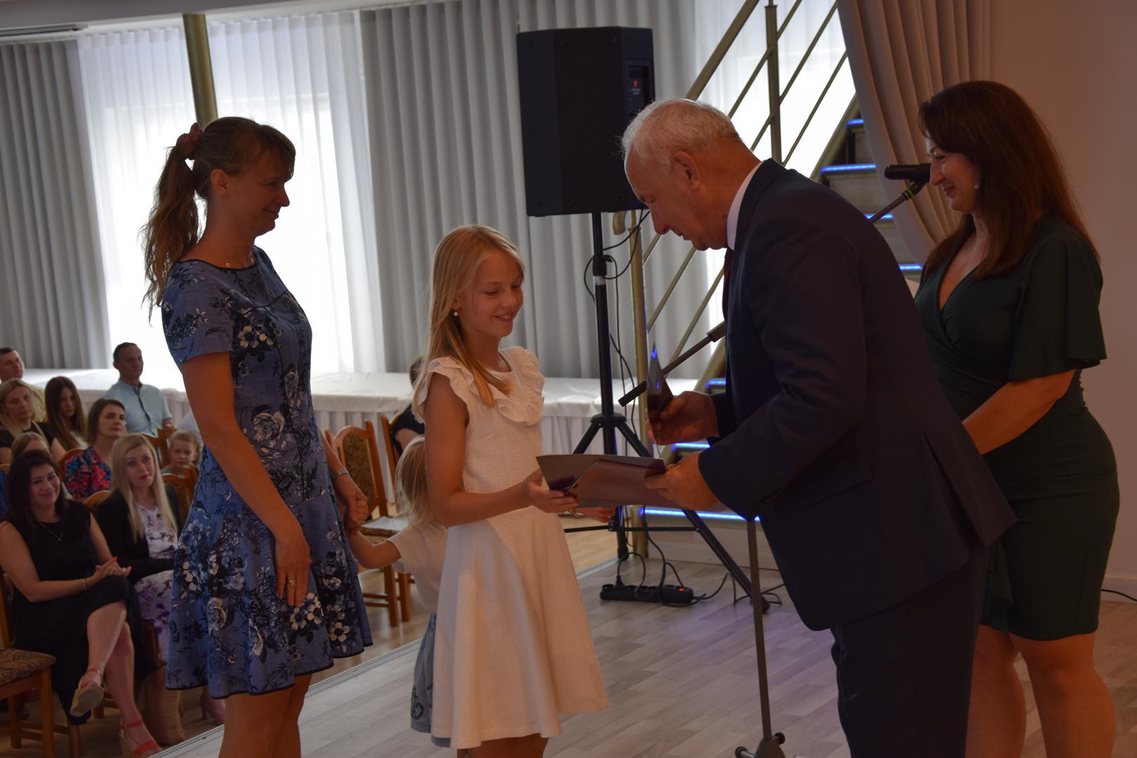 Zdjęcie przedstawia moment rozdania nagród i wyróżnień dla uczniów z najwyższą średnią ocen w Gminie Mierzęcice