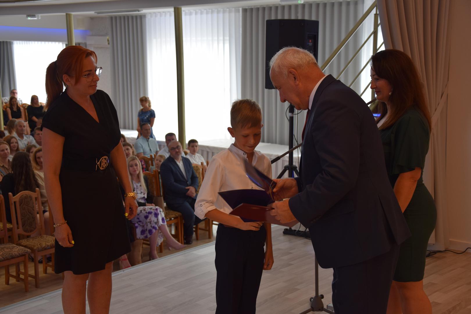 Zdjęcie przedstawia moment rozdania nagród i wyróżnień dla uczniów z najwyższą średnią ocen w Gminie Mierzęcice