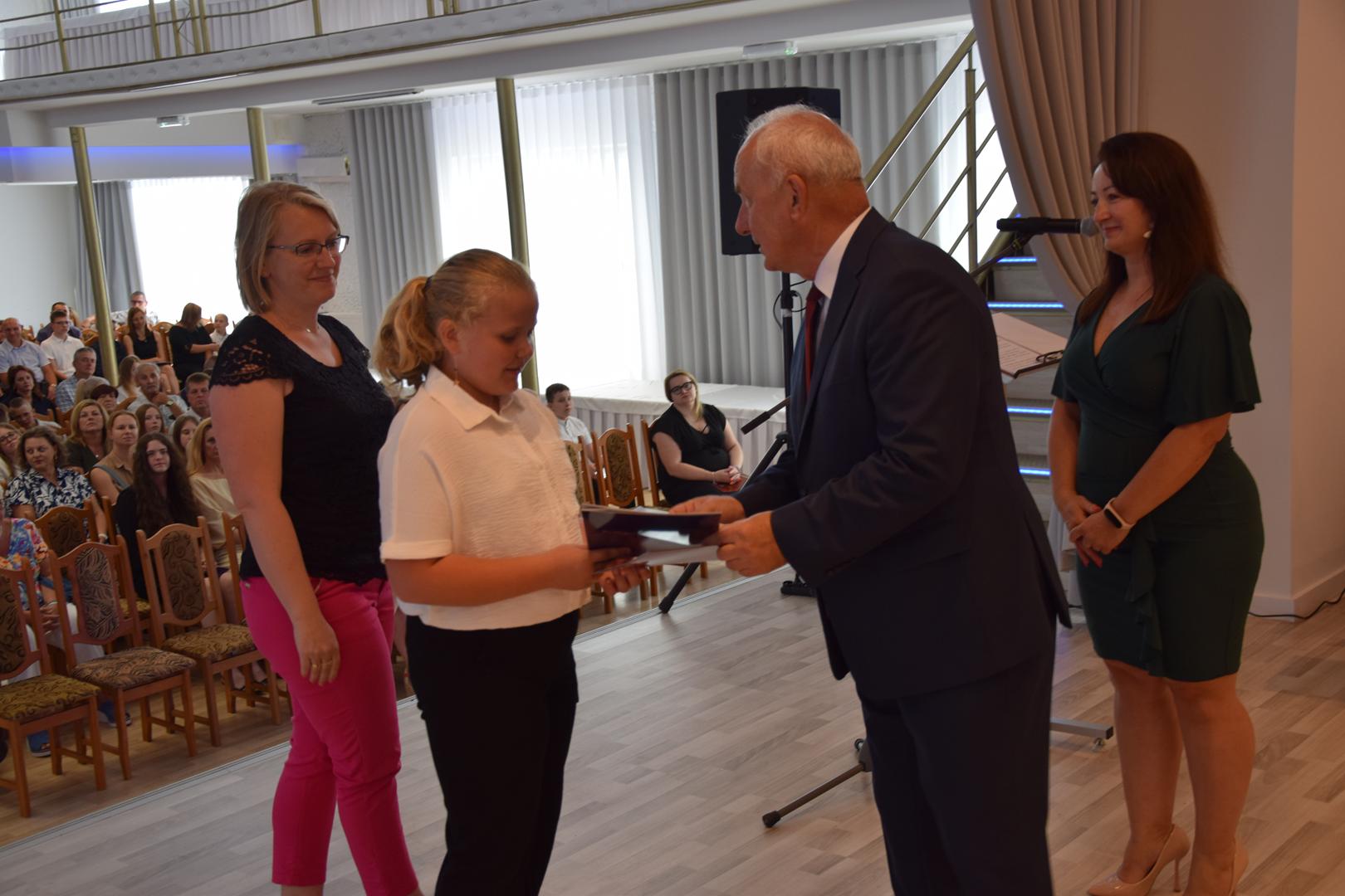 Zdjęcie przedstawia moment rozdania nagród i wyróżnień dla uczniów z najwyższą średnią ocen w Gminie Mierzęcice