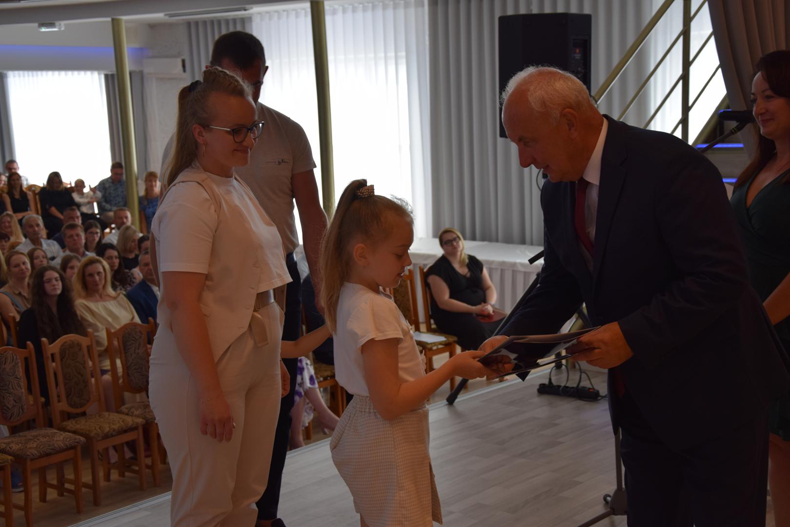 Zdjęcie przedstawia moment rozdania nagród i wyróżnień dla uczniów z najwyższą średnią ocen w Gminie Mierzęcice