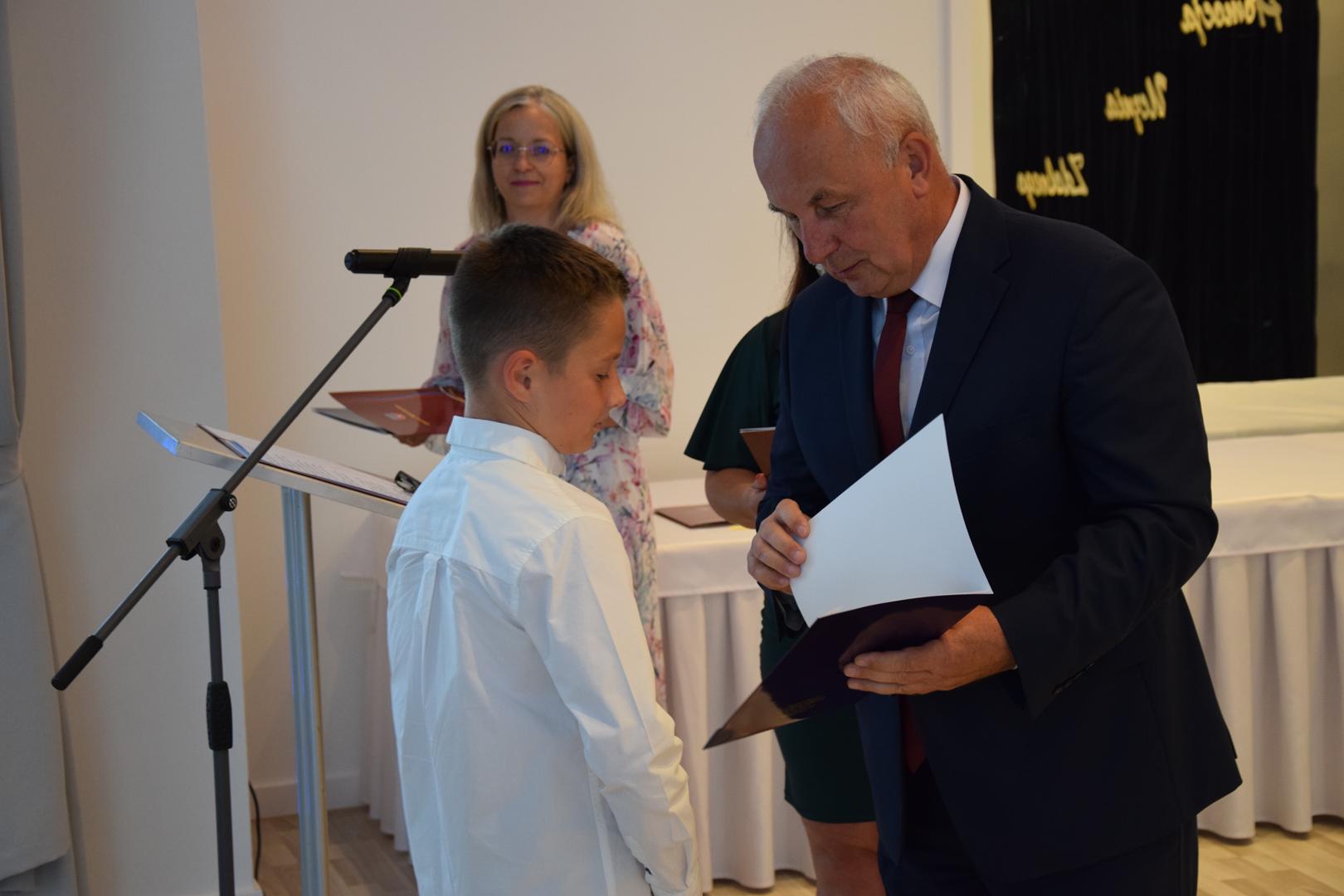 Zdjęcie przedstawia moment rozdania nagród i wyróżnień dla uczniów z najwyższą średnią ocen w Gminie Mierzęcice