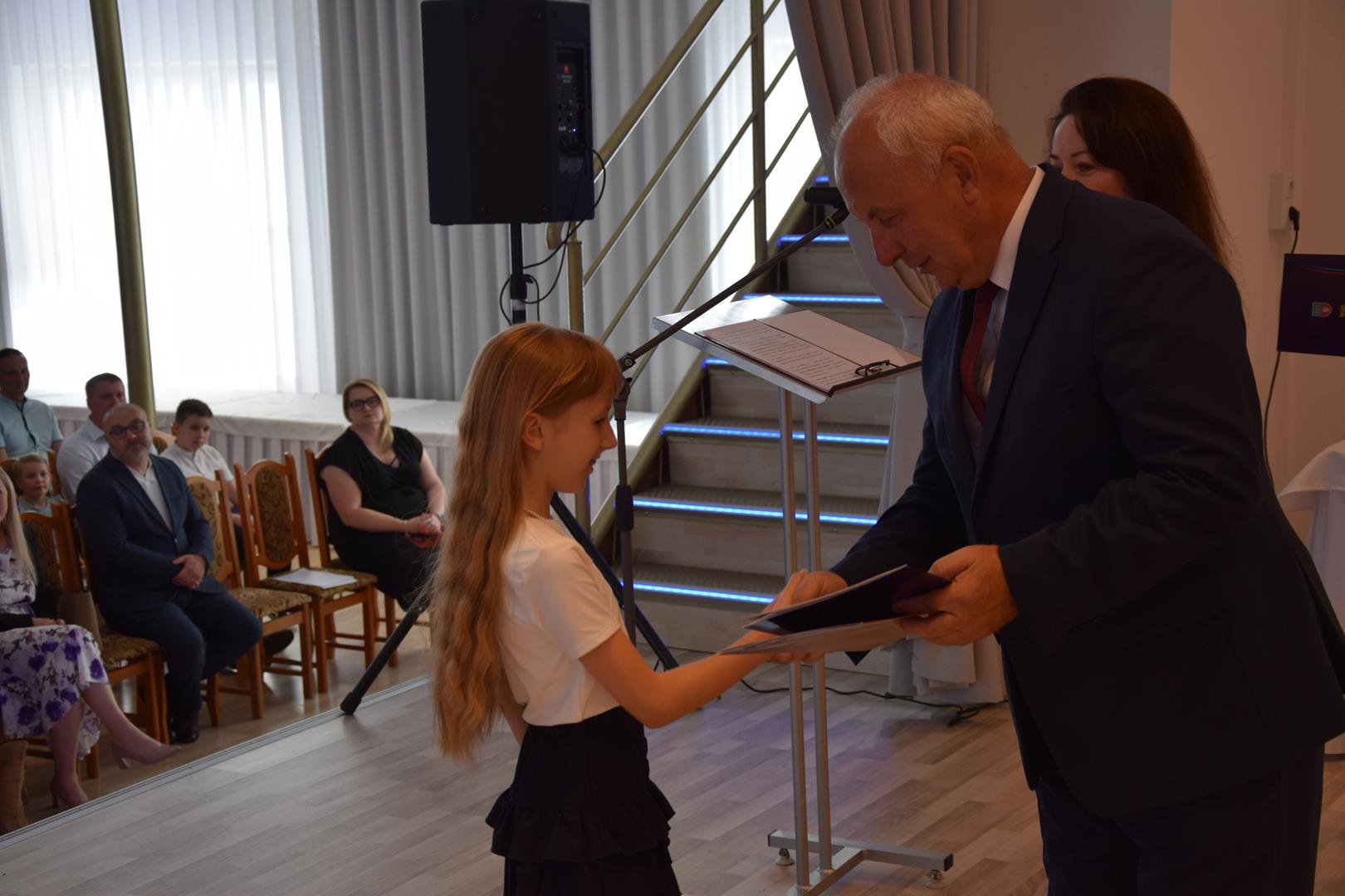 Zdjęcie przedstawia moment rozdania nagród i wyróżnień dla uczniów z najwyższą średnią ocen w Gminie Mierzęcice