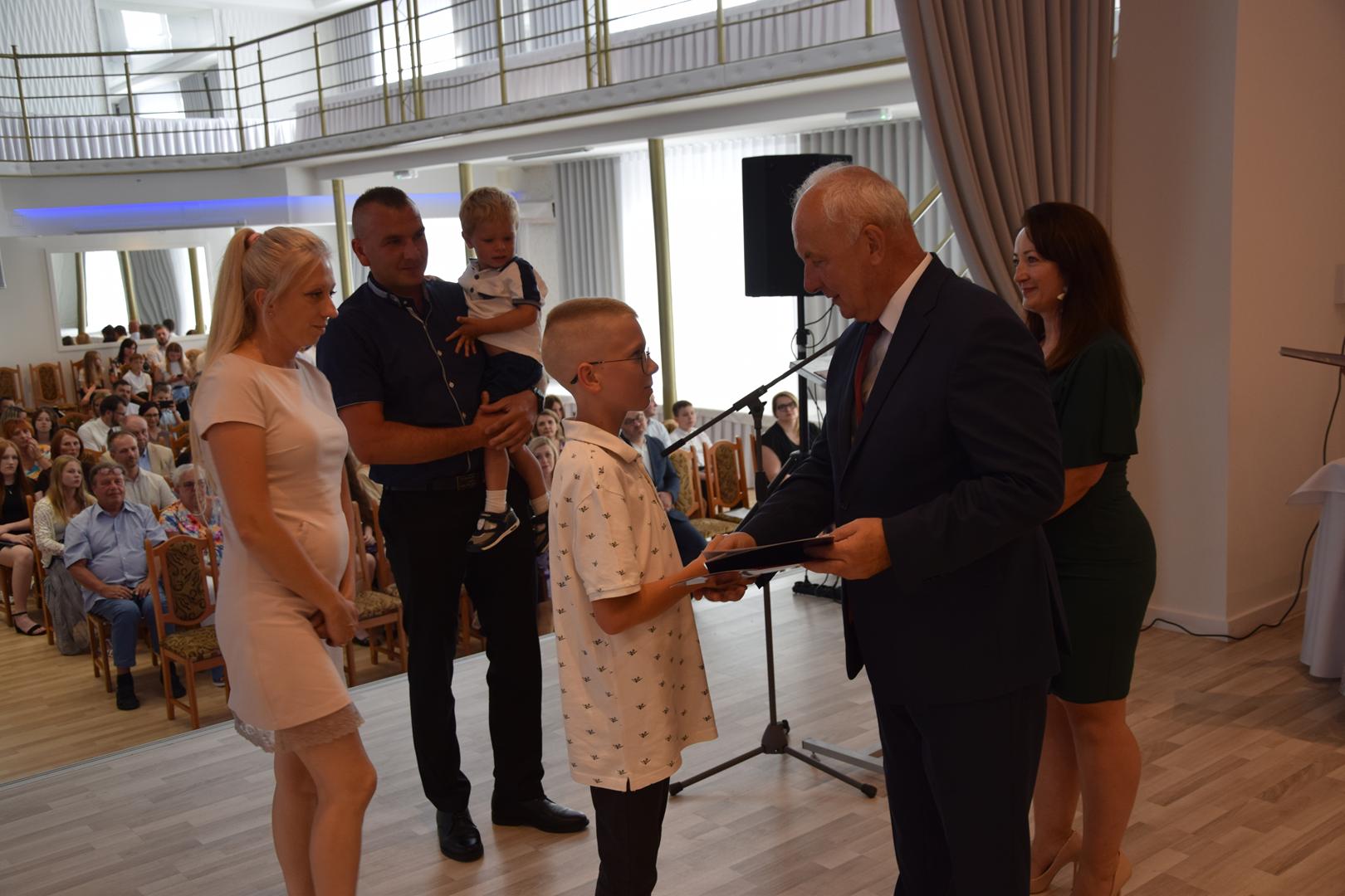 Zdjęcie przedstawia moment rozdania nagród i wyróżnień dla uczniów z najwyższą średnią ocen w Gminie Mierzęcice
