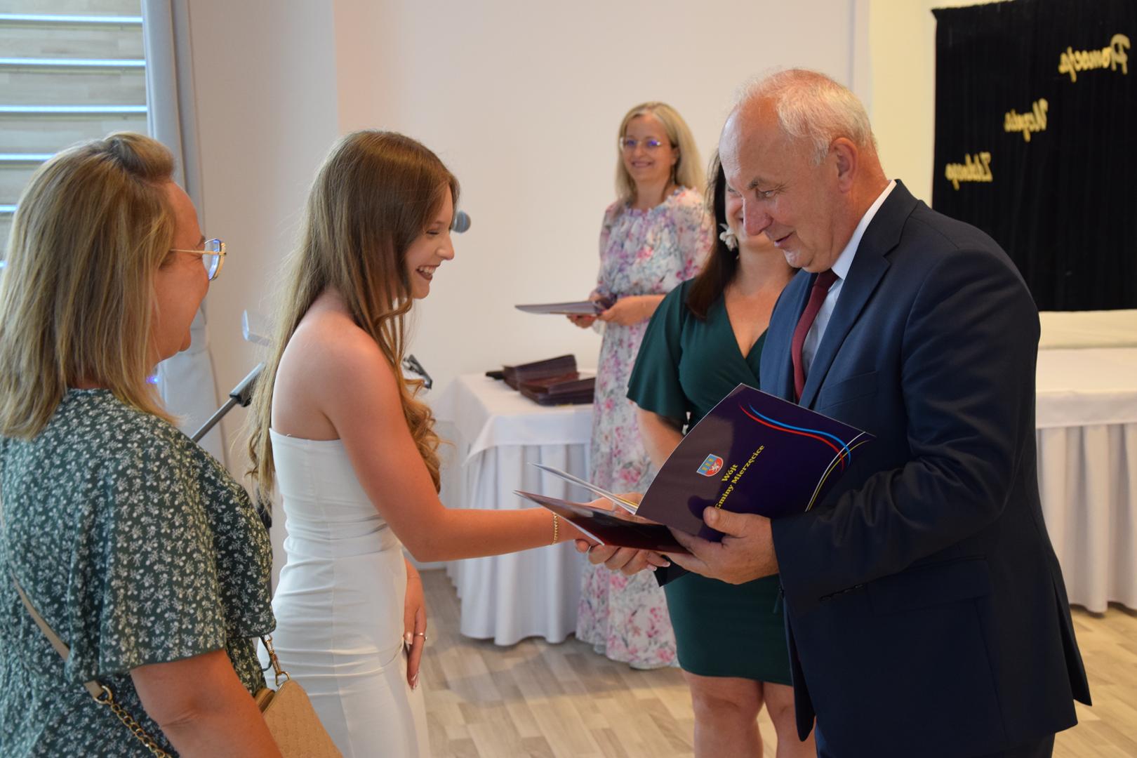 Zdjęcie przedstawia moment rozdania nagród i wyróżnień dla uczniów z najwyższą średnią ocen w Gminie Mierzęcice