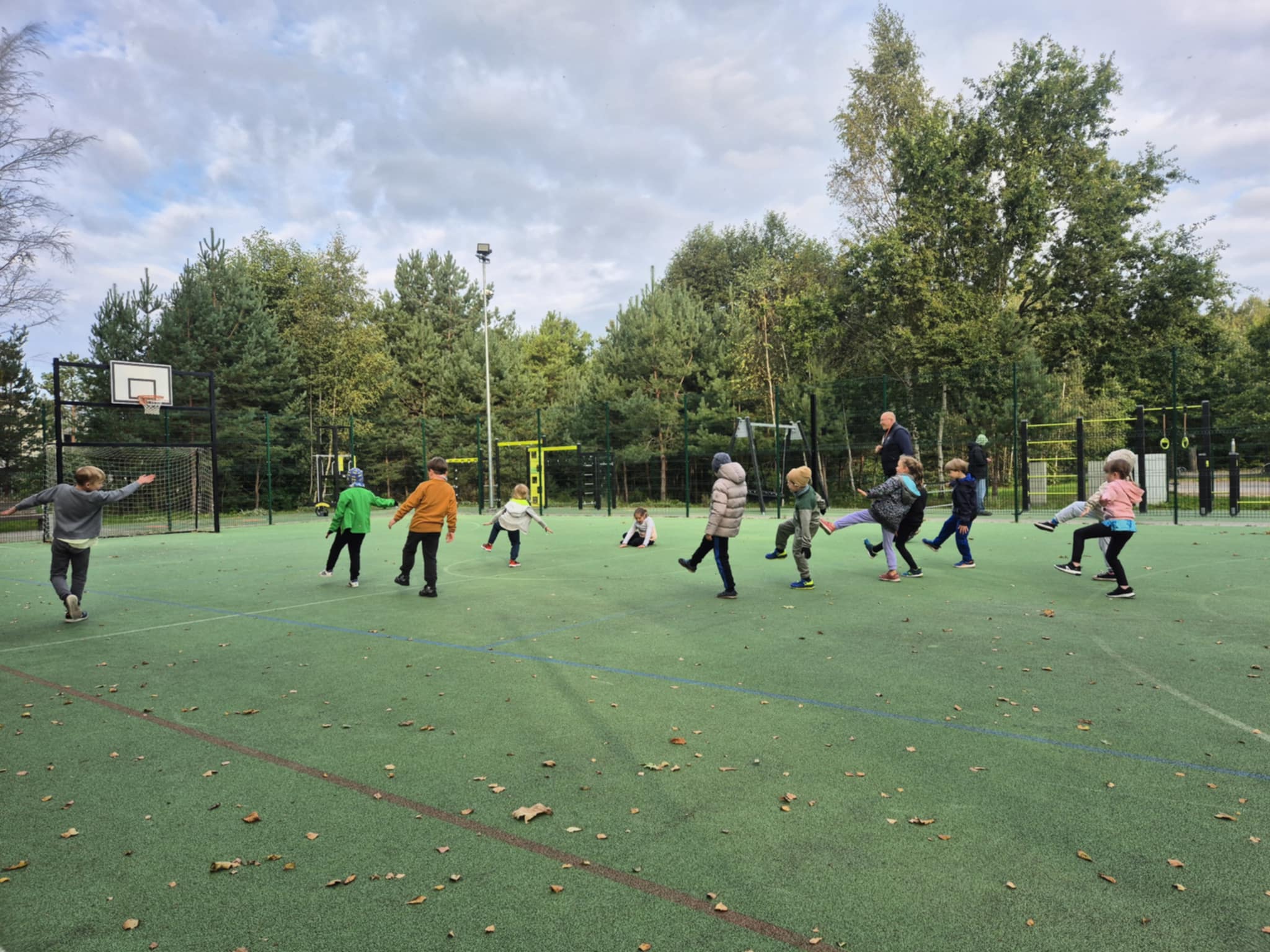 Zdjęcie przedstawia dzieci podczas gry na boisku