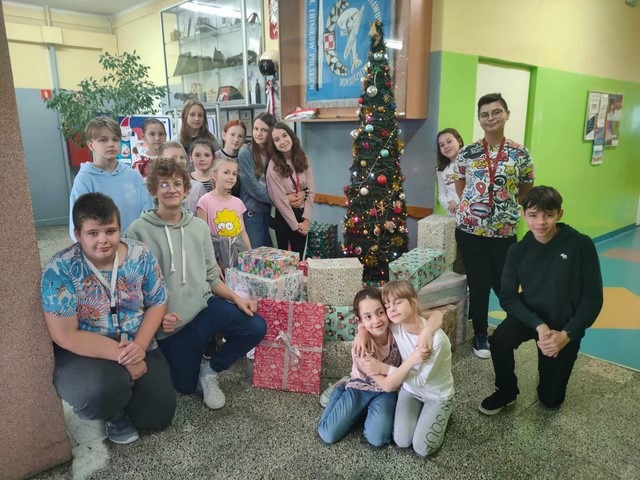 Zdjęcie przedstawiające wspólne zdjęcie uczniów na tle prezentów