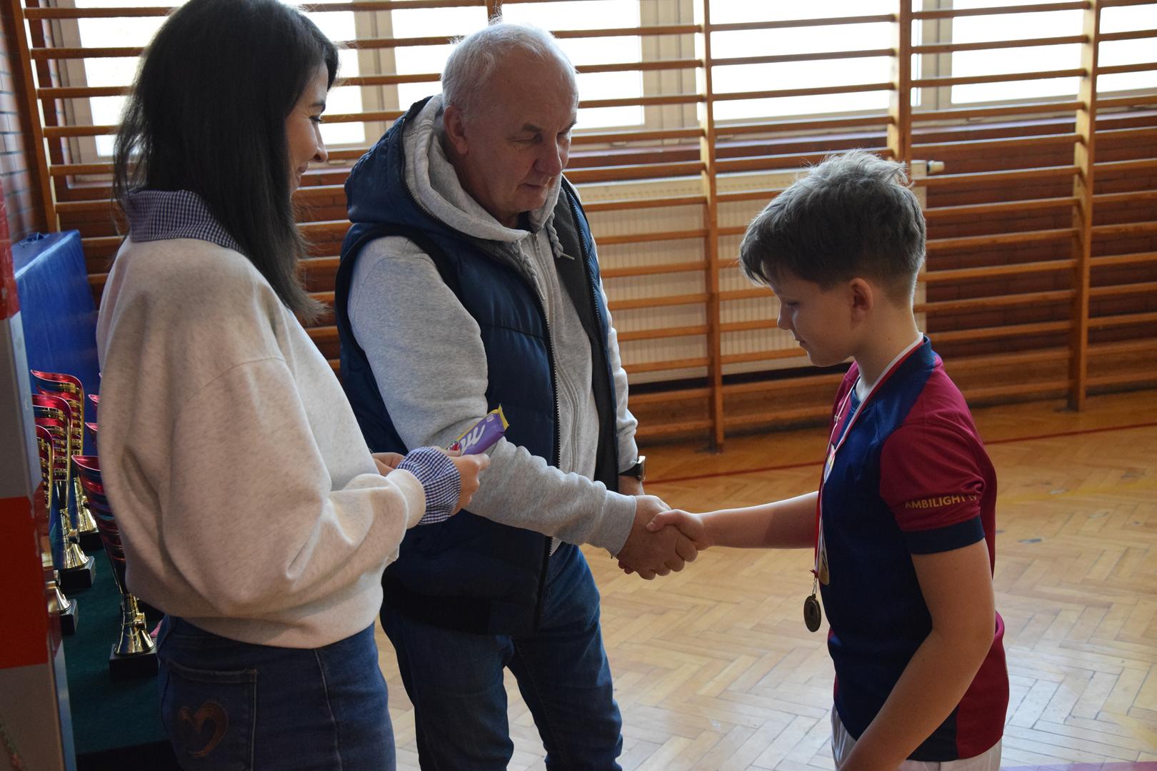 Zdjęcie przedstawia moment wręczania medali, dyplomów i pucharów