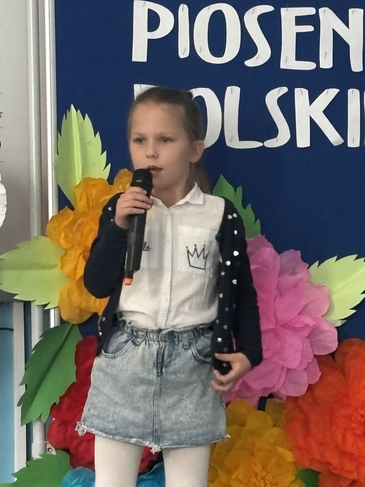 Zdjęcie przedstawia uczestnika konkursu wokalnego w&nbsp;trakcie występu