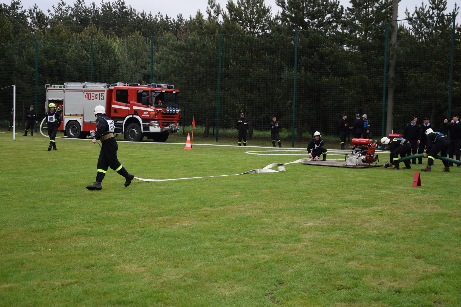 Zdjęcie przedstawiające strażaków podczas wykonywania konkurencji sportowo-pożarniczych